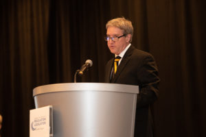 Photo of Dale Atkinson speaking at a podium
