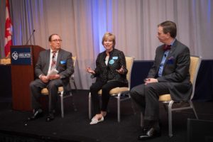 photograph of Tim Brown, Mary Jo Monahan, and Harold Dean seated on a stage