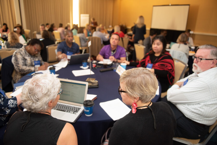 Meeting attendees engaged in conversation at a round table