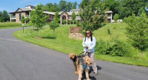 Photograph of woman with two dogs on a leash in front of ASWB's offices