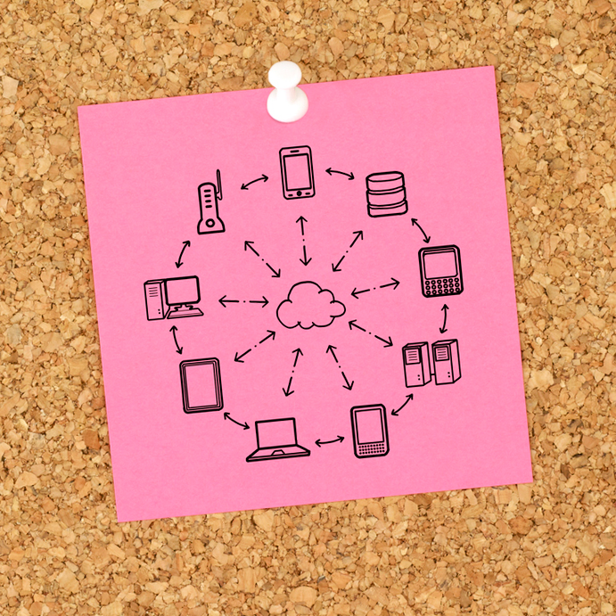 Pink notepaper with drawings of computers in a network, pinned to a cork board.
