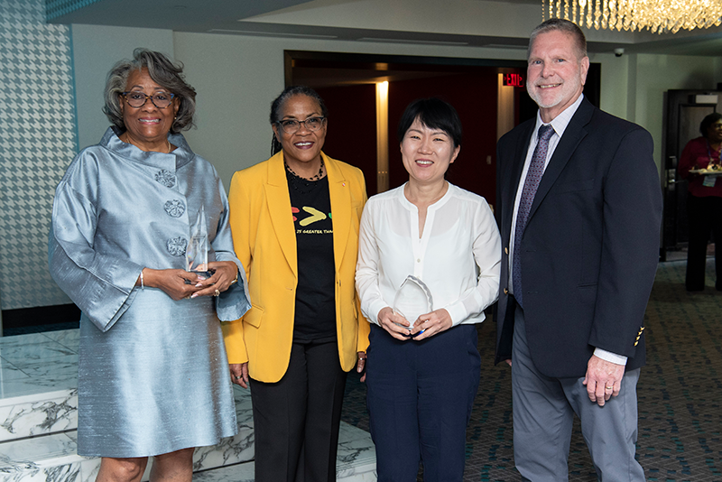 Photograph of M. Jenise Comer, Stacey D. Hardy-Chandler, Joy Kim, and Brian Philson. Jenise Comer and Joy Kim are holding glass awards presented by ASWB.